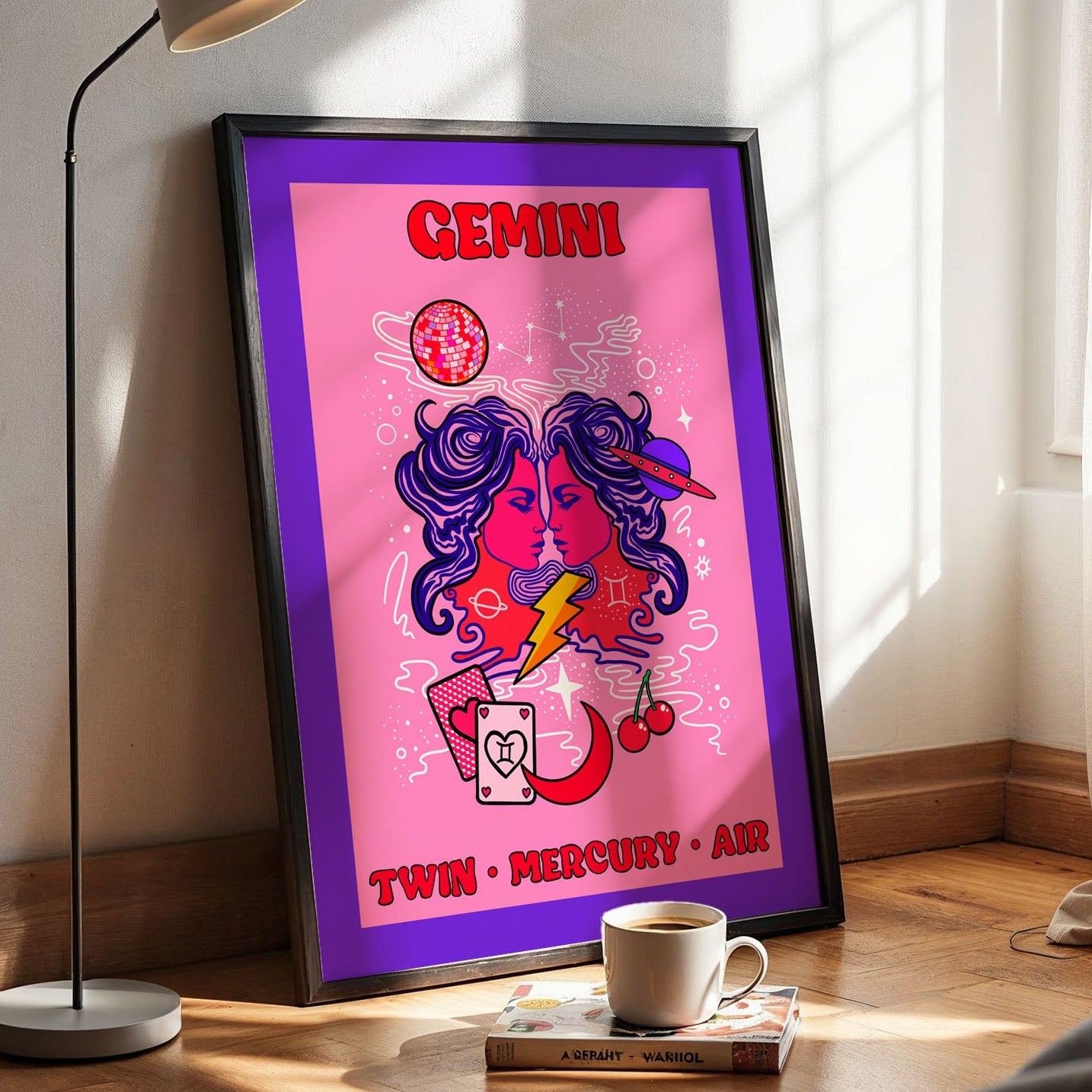 Framed astrological poster of Gemini on a wall next to a lamp and a cup of coffee.