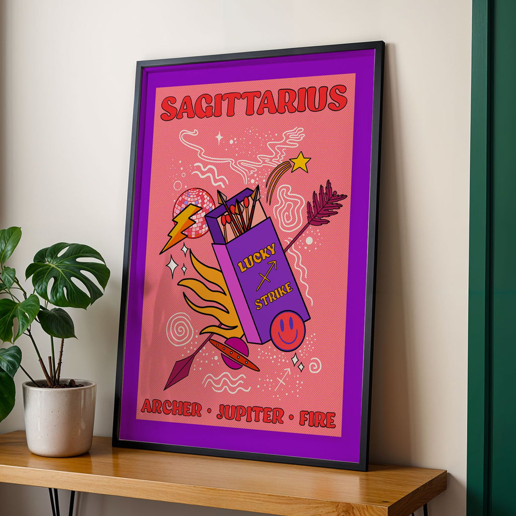Framed Sagittarius zodiac poster on a wooden shelf with a plant in the background